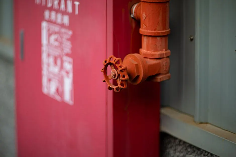 Detailed view of a red fire hydrant with valve in an urban setting in Taiwan.